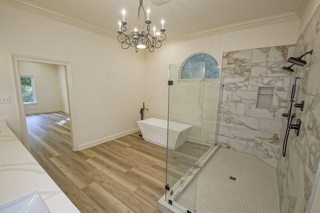full bathroom with a tile shower, crown molding, a notable chandelier, wood finished floors, and a freestanding bath