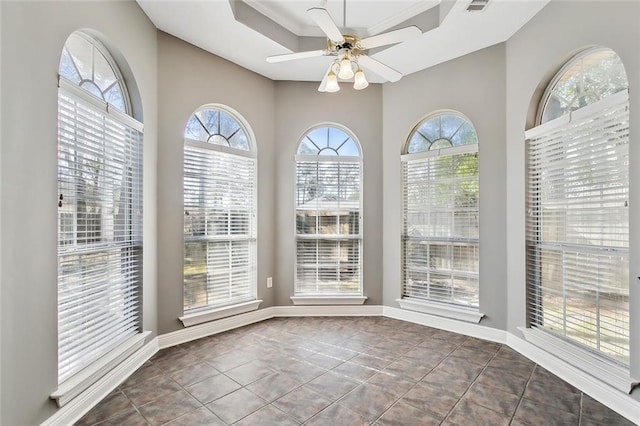 unfurnished dining area with ceiling fan, plenty of natural light, and dark tile patterned floors