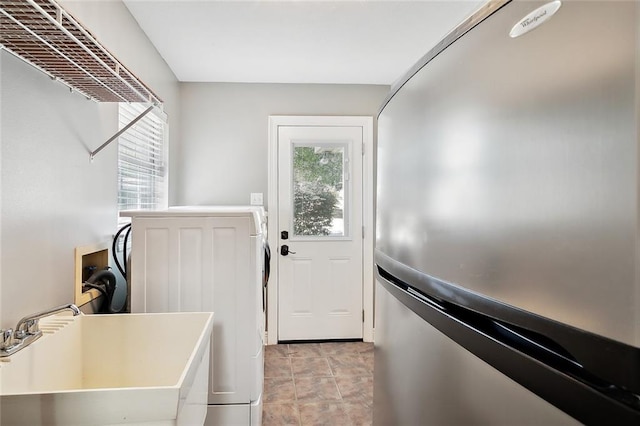 laundry room featuring washer / dryer, sink, and a wealth of natural light