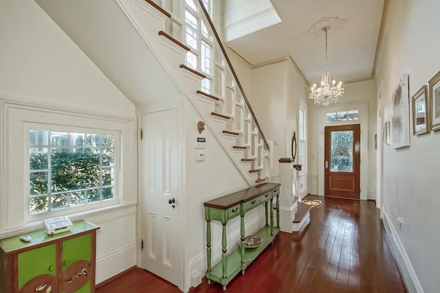 foyer entrance with a notable chandelier and dark hardwood / wood-style flooring