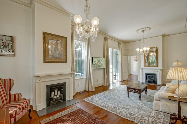 living room featuring an inviting chandelier, ornamental molding, and hardwood / wood-style flooring