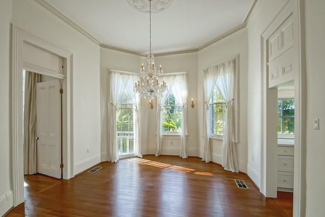 unfurnished dining area with ornamental molding, dark hardwood / wood-style floors, and a chandelier