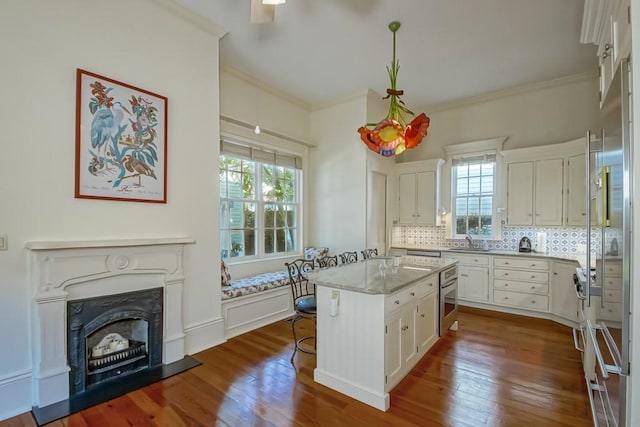 kitchen featuring a wealth of natural light, a kitchen island, white cabinetry, and dark hardwood / wood-style floors