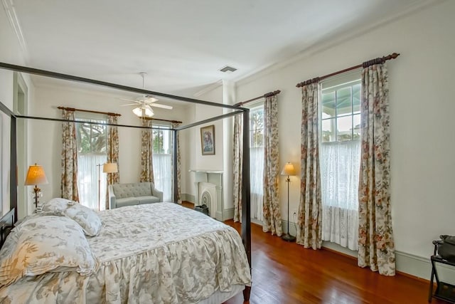 bedroom featuring dark wood-type flooring, ceiling fan, crown molding, and multiple windows