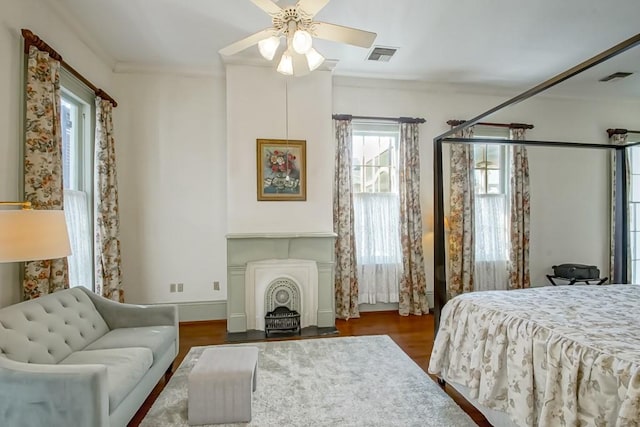 bedroom with ornamental molding, dark wood-type flooring, and ceiling fan