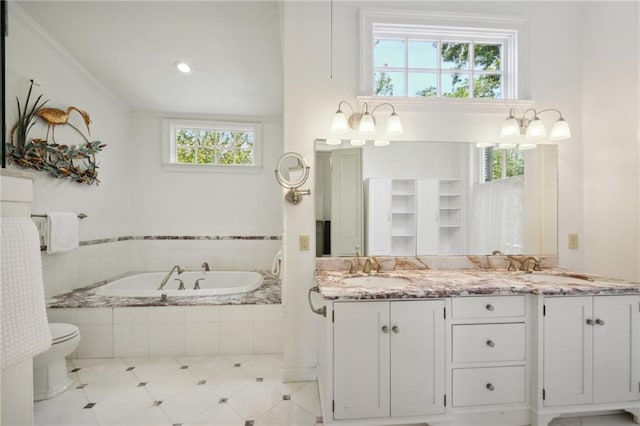 bathroom with vanity, ornamental molding, a relaxing tiled tub, and toilet