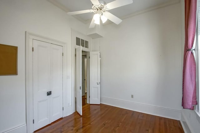 unfurnished bedroom with a closet, wood-type flooring, and ceiling fan