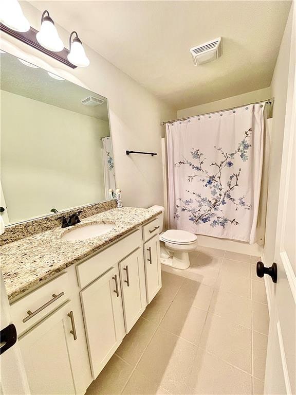 bathroom with vanity, toilet, tile patterned floors, and a shower with shower curtain