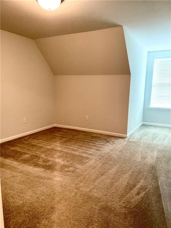 additional living space with carpet floors and vaulted ceiling