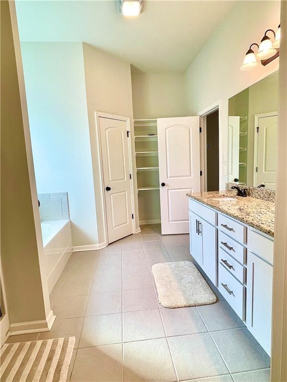 bathroom with vanity, a tub, and tile patterned flooring