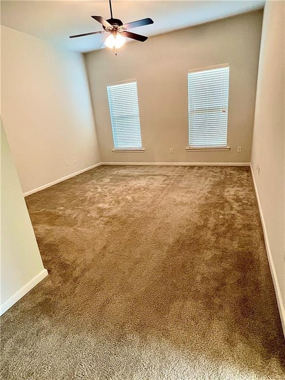 carpeted spare room with ceiling fan