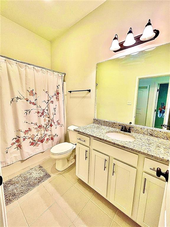 bathroom featuring vanity, toilet, and tile patterned flooring