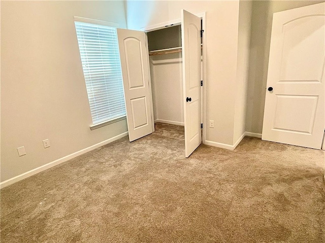 unfurnished bedroom featuring light colored carpet and a closet