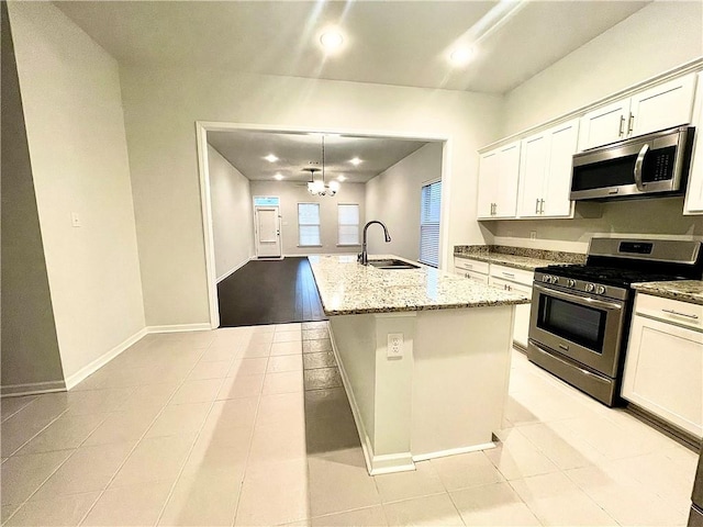 kitchen featuring hanging light fixtures, a center island with sink, sink, white cabinets, and appliances with stainless steel finishes