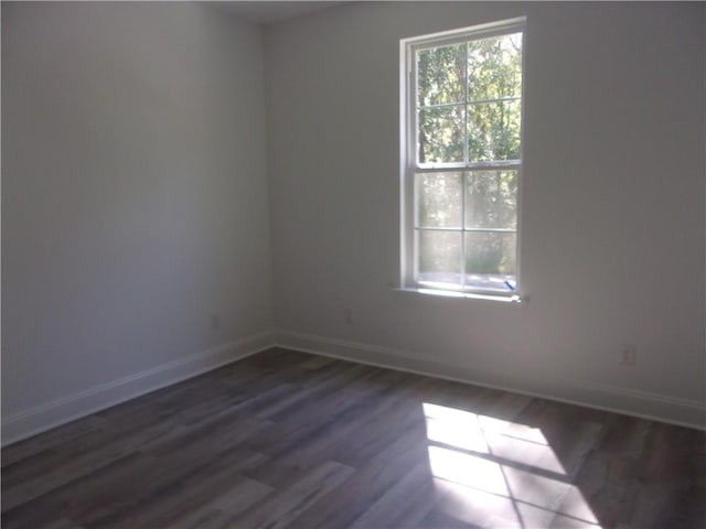 unfurnished room with dark hardwood / wood-style flooring