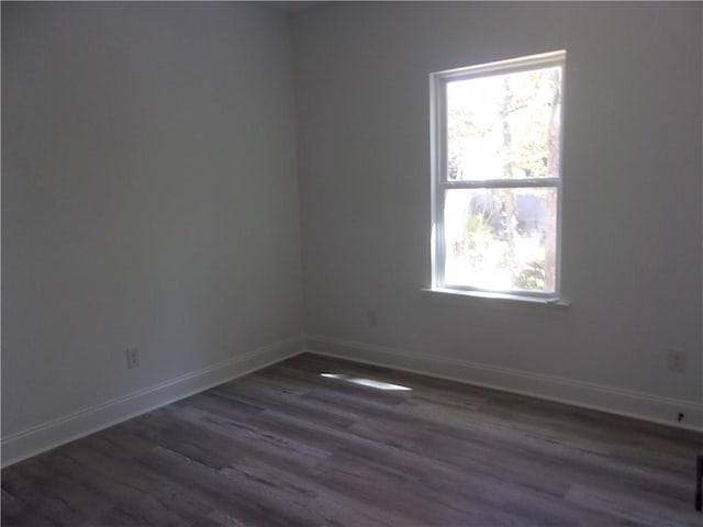 empty room with plenty of natural light and dark hardwood / wood-style floors