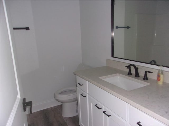 bathroom with vanity, wood-type flooring, and toilet