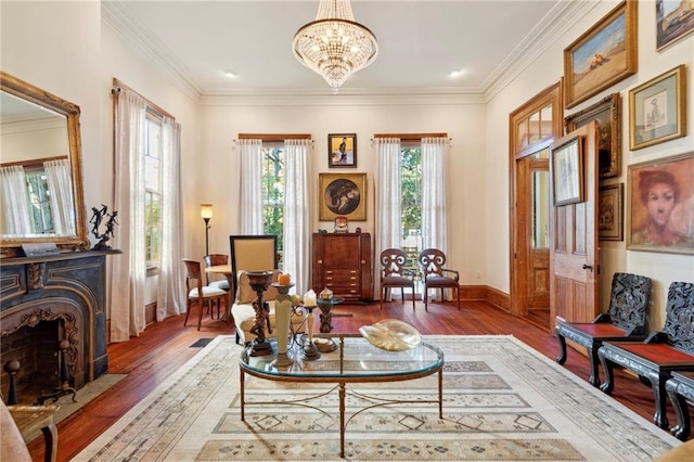 living area with ornamental molding, an inviting chandelier, and dark hardwood / wood-style floors