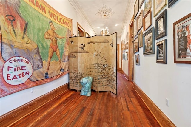 hall featuring ornamental molding, a chandelier, and hardwood / wood-style floors