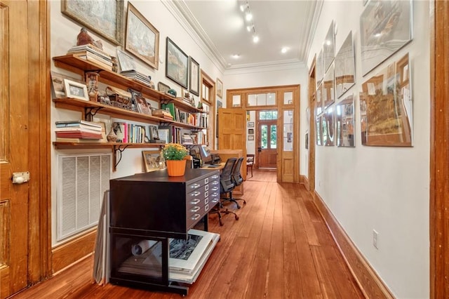 office space with rail lighting, ornamental molding, and hardwood / wood-style floors