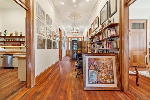 hall with a notable chandelier, wood-type flooring, and crown molding