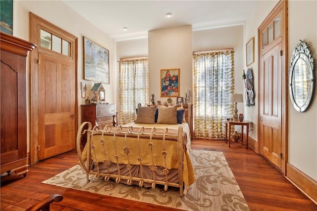 bedroom with hardwood / wood-style floors and multiple windows