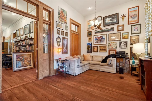 sitting room featuring a notable chandelier, ornamental molding, and wood-type flooring