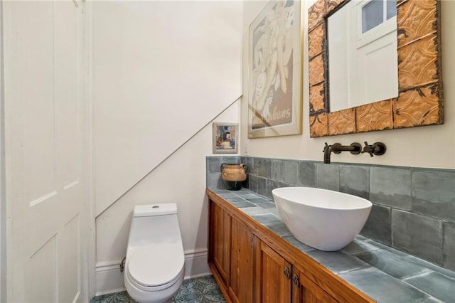 bathroom with toilet, tasteful backsplash, and vanity