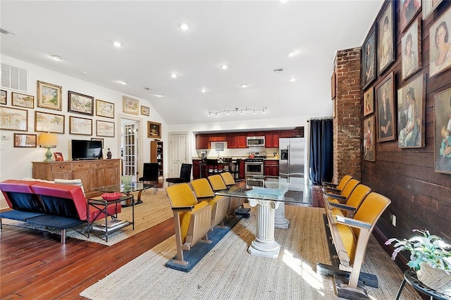 living room featuring wood-type flooring and vaulted ceiling