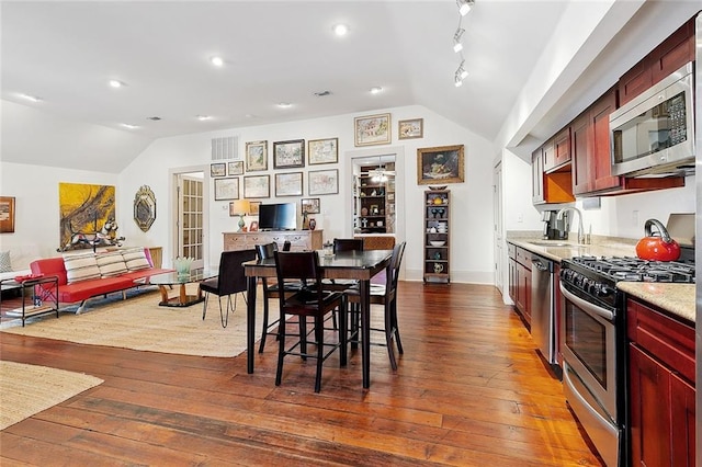 dining area featuring lofted ceiling, dark hardwood / wood-style floors, and sink