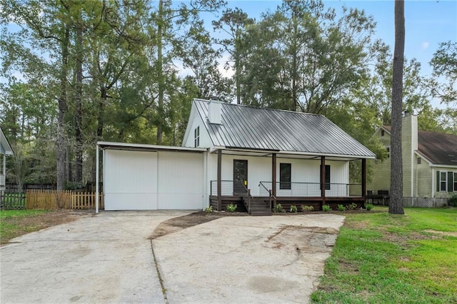 view of front of house with a front yard, covered porch, and a garage