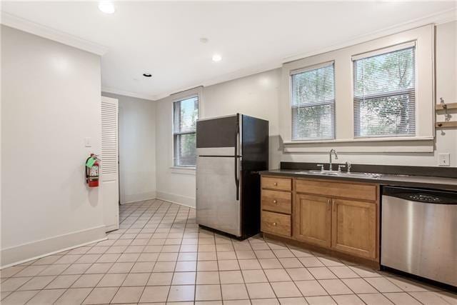 kitchen featuring ornamental molding, a healthy amount of sunlight, stainless steel appliances, and sink