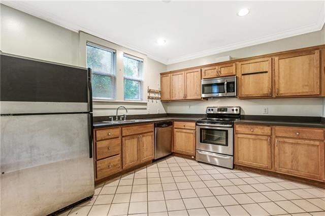 kitchen with sink, appliances with stainless steel finishes, crown molding, and light tile patterned floors