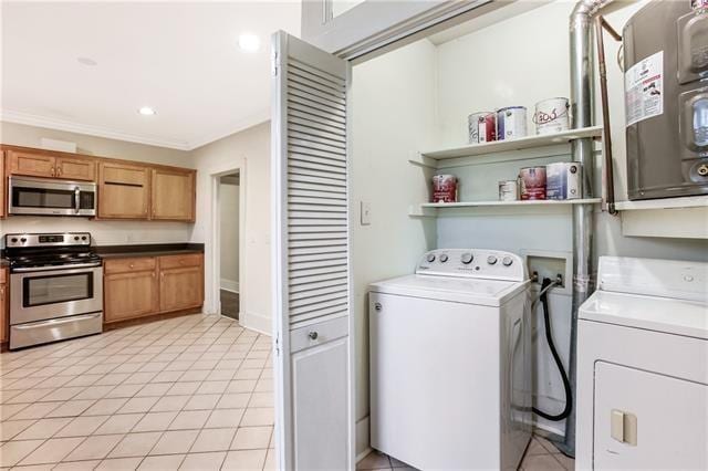 clothes washing area featuring crown molding and washer and clothes dryer