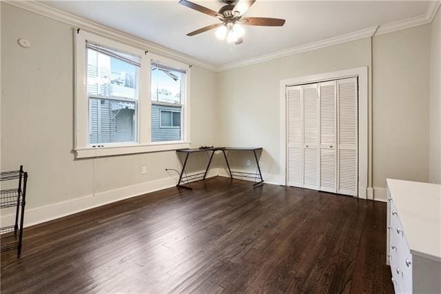 unfurnished bedroom with dark wood-type flooring, crown molding, a closet, and ceiling fan