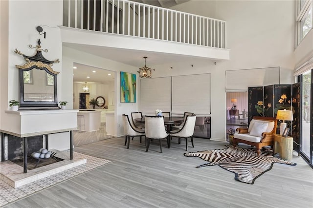 dining room featuring a high ceiling and light hardwood / wood-style flooring