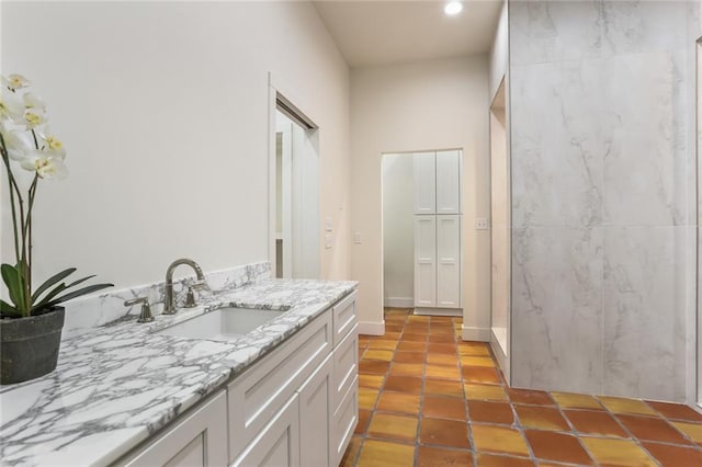 bathroom with walk in shower, tile patterned flooring, and vanity