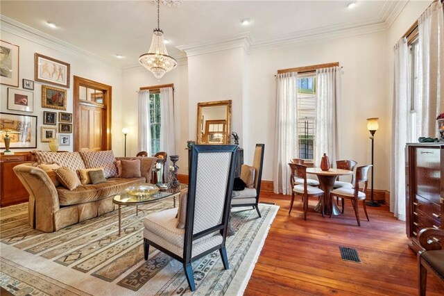 1221 N Tonti St, New Orleans, LA 70119 - living area with healthy amount of natural light, wood-type flooring, crown molding, baseboards, and a chandelier