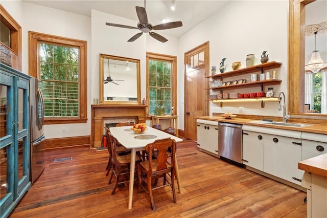 1221 N Tonti St, New Orleans, LA 70119 - kitchen with stainless steel dishwasher, a sink, ceiling fan, white cabinetry, and hardwood / wood-style flooring