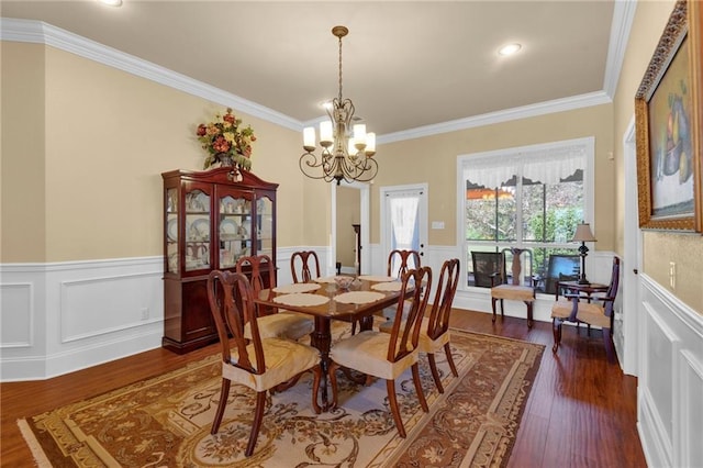 dining area with an inviting chandelier, crown molding, and dark wood-type flooring