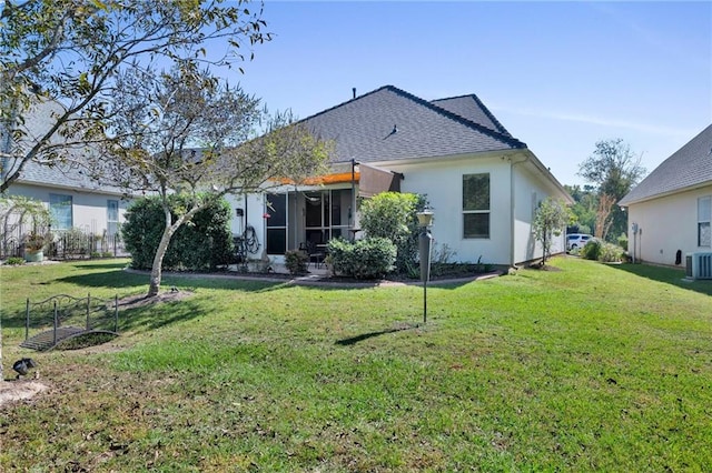 back of property featuring a sunroom, a lawn, and cooling unit