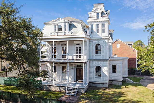 view of front facade featuring a front lawn and a balcony