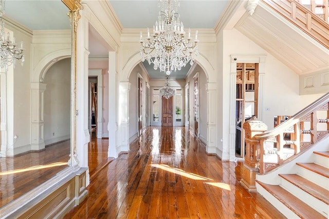 foyer featuring crown molding, a notable chandelier, and dark hardwood / wood-style floors