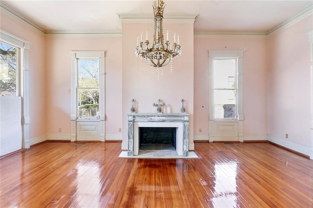 unfurnished living room featuring ornamental molding, a chandelier, and hardwood / wood-style floors