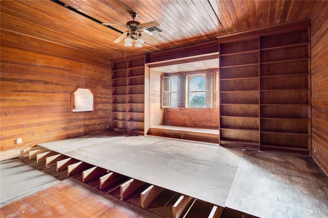 spare room featuring wood ceiling, wood walls, and ceiling fan