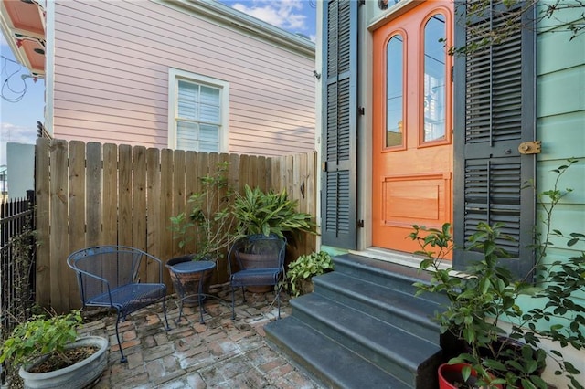 entrance to property with a patio area and fence