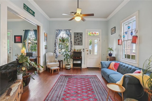 sitting room featuring wood-type flooring, visible vents, and crown molding