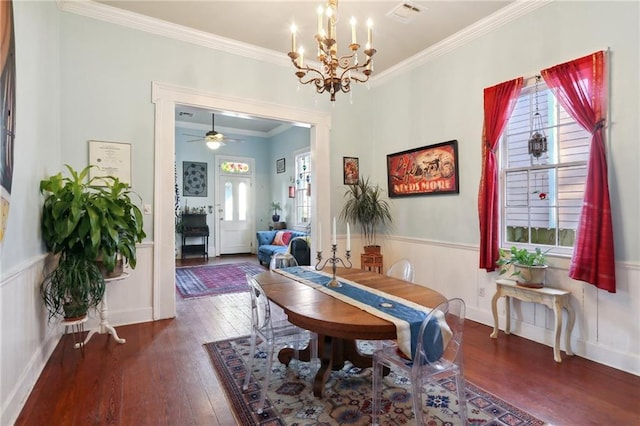 dining area with a notable chandelier, a wainscoted wall, visible vents, hardwood / wood-style floors, and crown molding