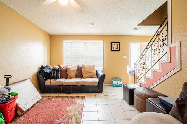 tiled living room with a textured ceiling and ceiling fan