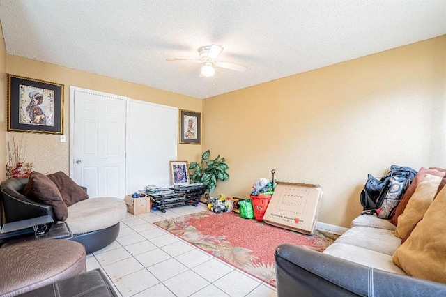 living room featuring ceiling fan, a textured ceiling, and light tile patterned flooring